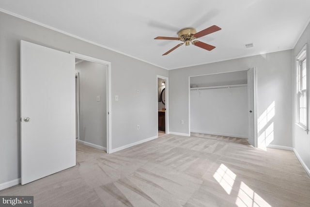 unfurnished bedroom featuring ornamental molding, light colored carpet, ceiling fan, ensuite bath, and a closet