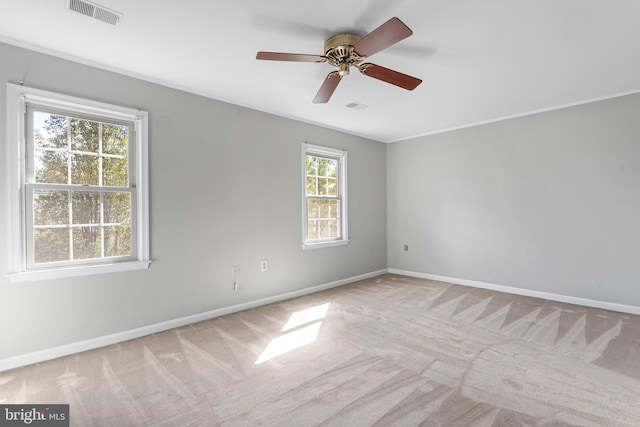 unfurnished room featuring crown molding, light carpet, and ceiling fan