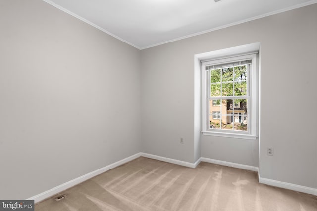 spare room featuring ornamental molding and light colored carpet