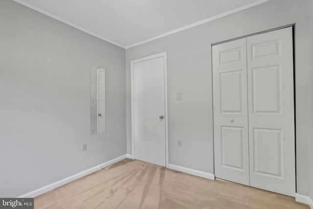 unfurnished bedroom with ornamental molding, light colored carpet, and a closet