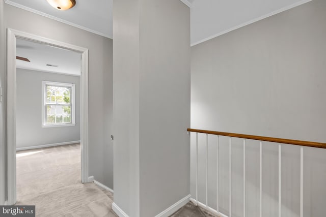 corridor featuring ornamental molding and light colored carpet