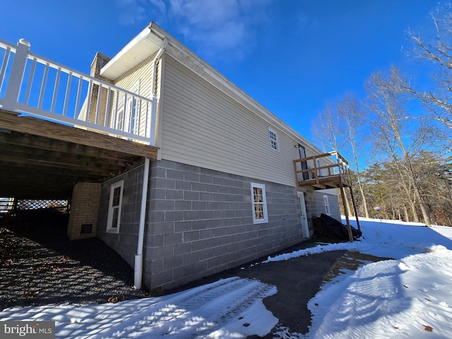 view of snowy exterior with a deck