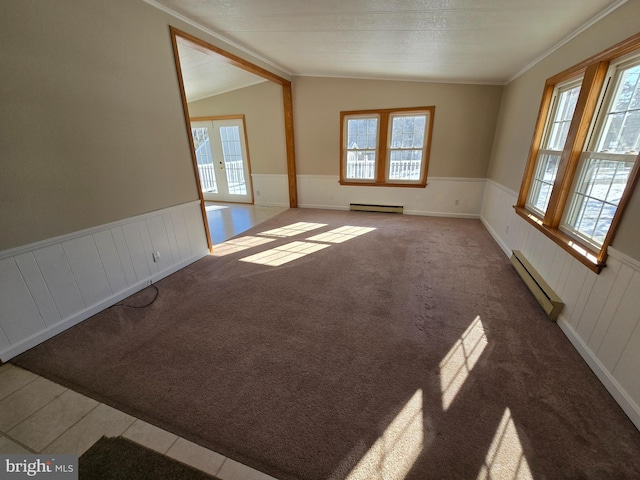 carpeted empty room featuring a baseboard radiator, plenty of natural light, and french doors