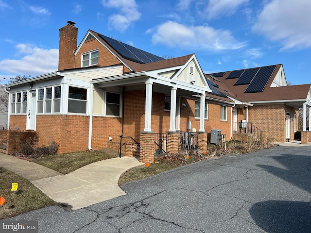 view of front of house with cooling unit and solar panels