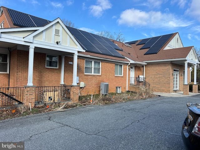 view of property exterior with central AC unit and solar panels