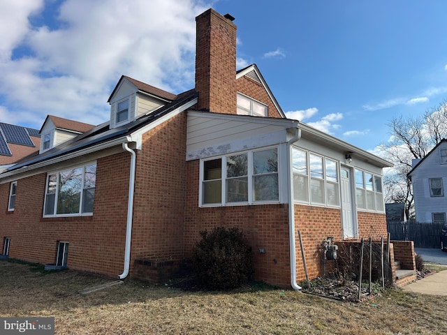 view of home's exterior with a sunroom