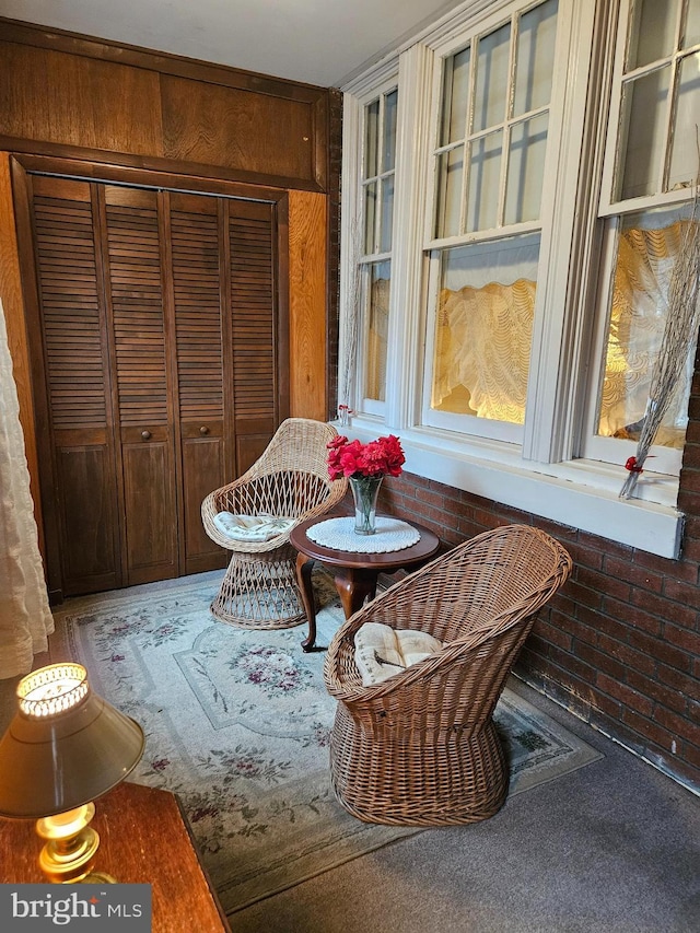 interior space featuring brick wall and carpet flooring