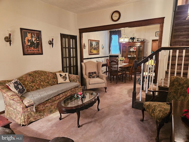 living room featuring carpet flooring, a notable chandelier, and a textured ceiling