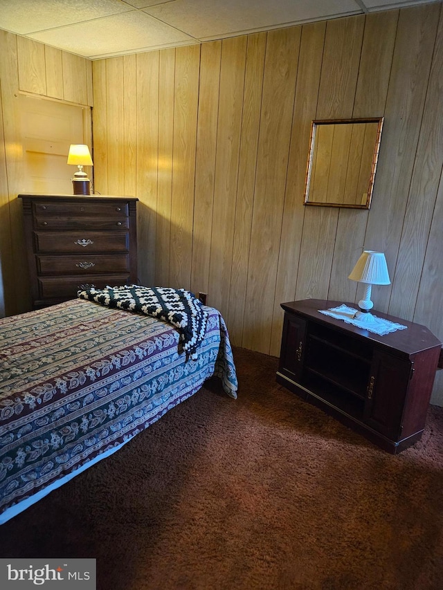 carpeted bedroom with wood walls