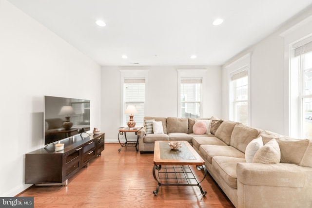 living room with light wood-style floors, recessed lighting, and baseboards