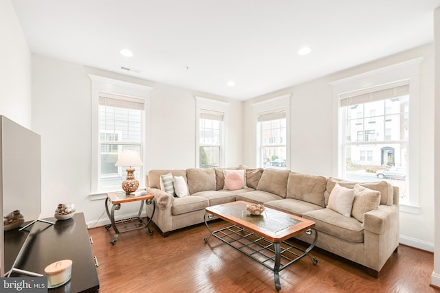 living room featuring recessed lighting, wood finished floors, visible vents, and baseboards