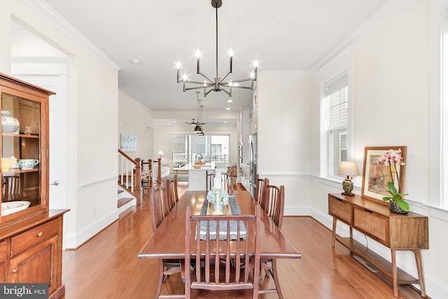 dining area featuring light wood-type flooring, plenty of natural light, and stairway