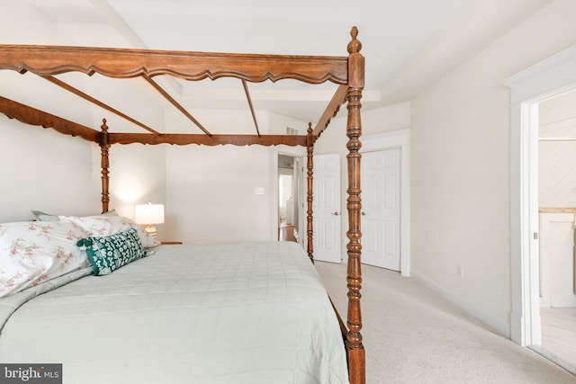 bedroom with light carpet, connected bathroom, and baseboards