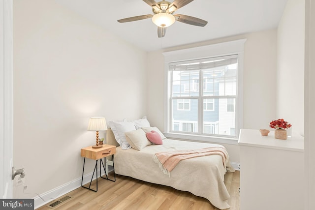 bedroom featuring a ceiling fan, light wood-type flooring, visible vents, and baseboards