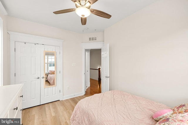 bedroom featuring a ceiling fan, light wood-type flooring, visible vents, and baseboards