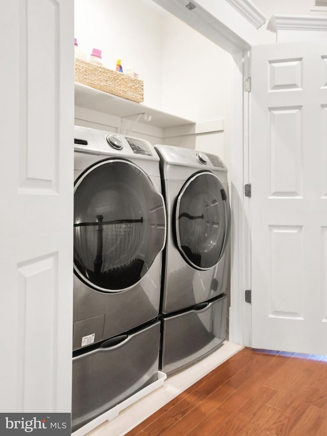 laundry room featuring laundry area, washer and dryer, and wood finished floors