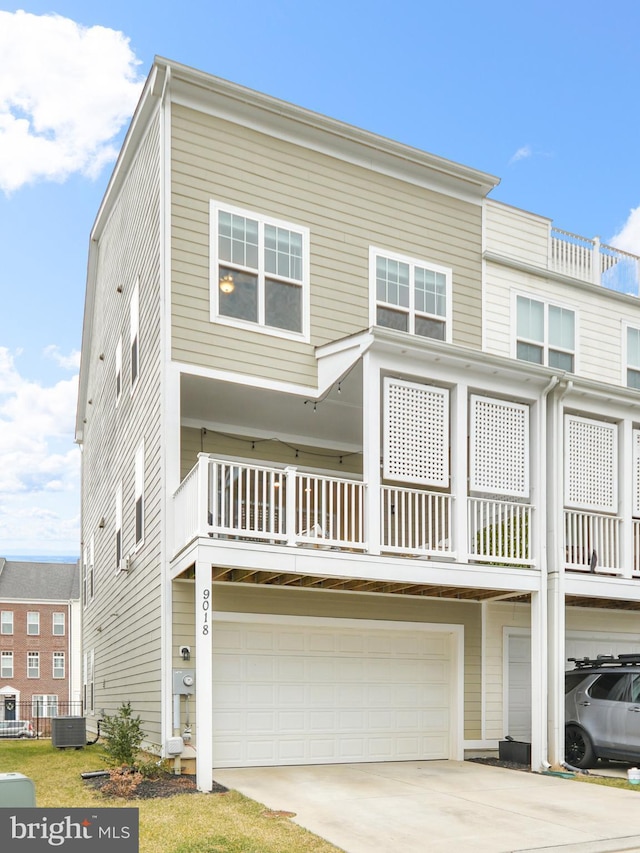 townhome / multi-family property featuring a garage, central AC unit, and concrete driveway