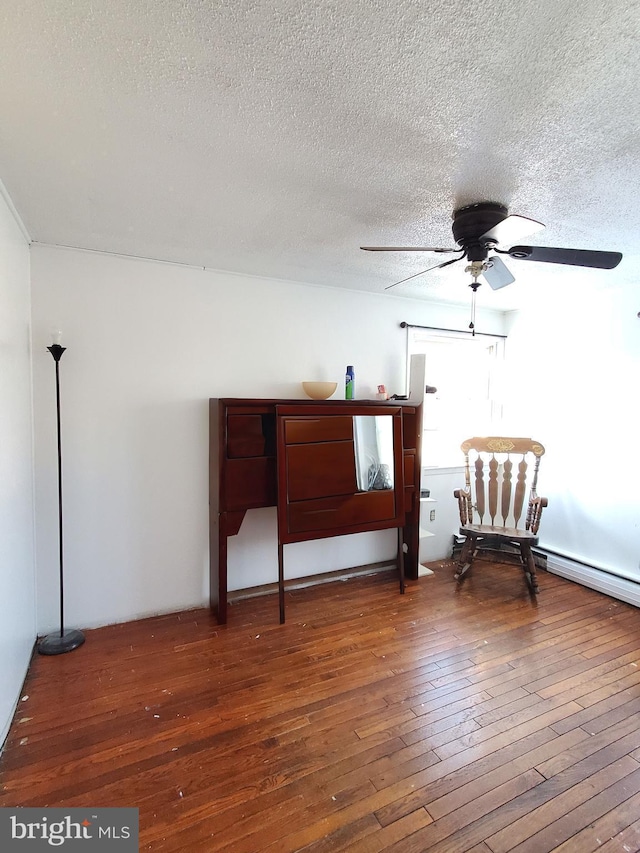 sitting room with wood-type flooring, a textured ceiling, and ceiling fan