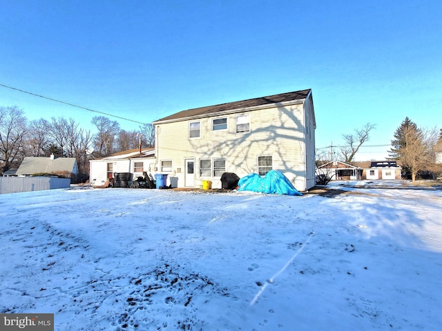 view of snow covered back of property