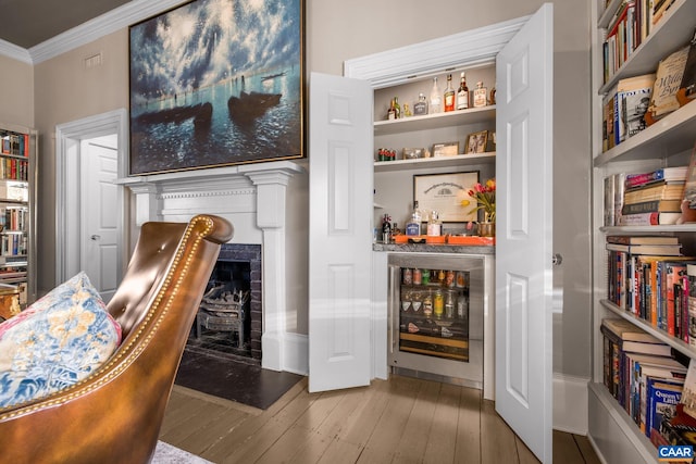 interior space with hardwood / wood-style flooring, crown molding, indoor bar, and wine cooler