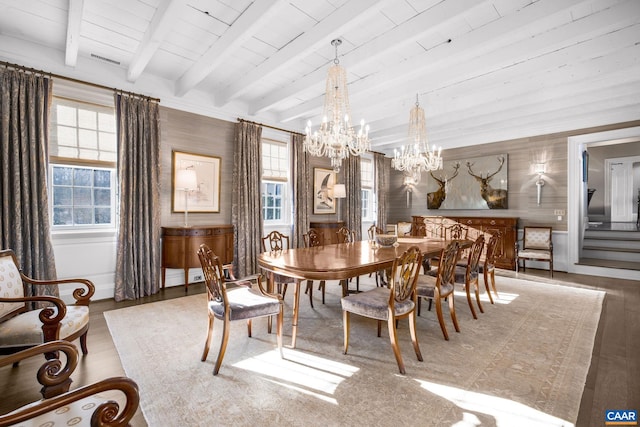 dining area featuring hardwood / wood-style flooring, an inviting chandelier, and beamed ceiling