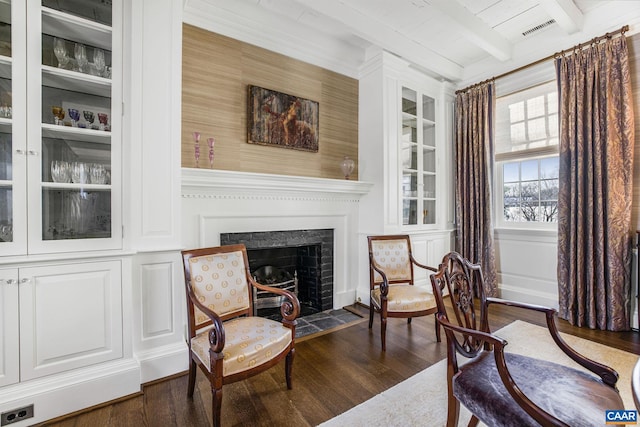 living area with beamed ceiling and dark hardwood / wood-style floors