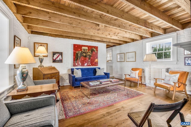 living area featuring beamed ceiling, wood-type flooring, and wooden ceiling