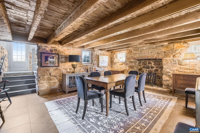 tiled dining space featuring wood ceiling, beam ceiling, and plenty of natural light