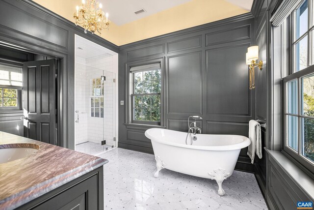 bathroom featuring vanity, separate shower and tub, a wealth of natural light, and a chandelier