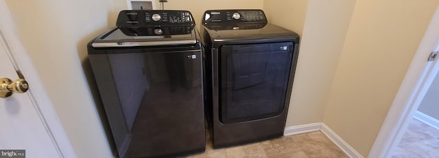 laundry area featuring laundry area, baseboards, and washing machine and clothes dryer