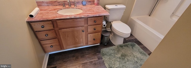 bathroom with toilet, wood finished floors, and vanity