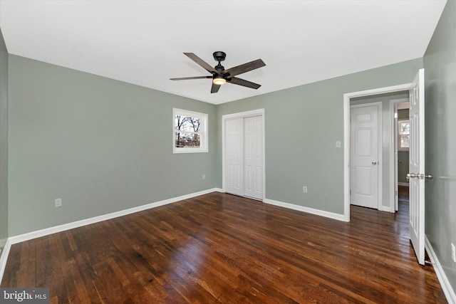 unfurnished bedroom with dark hardwood / wood-style floors, ceiling fan, and a closet