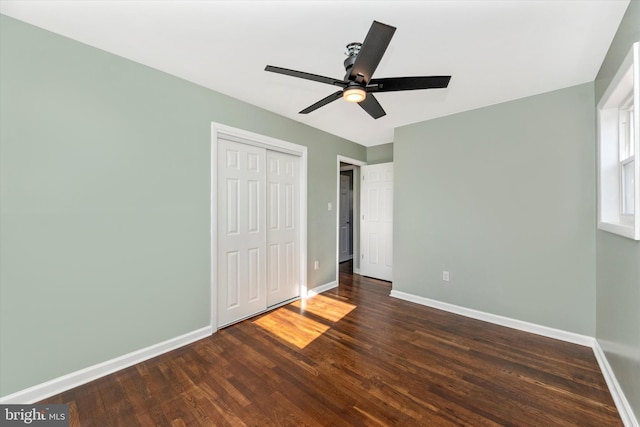 unfurnished bedroom with a closet, dark hardwood / wood-style floors, and ceiling fan