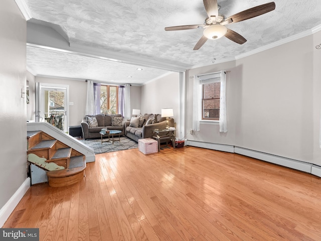 living room with crown molding, a textured ceiling, light hardwood / wood-style floors, and baseboard heating