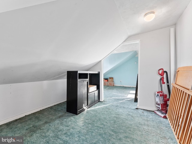 additional living space with lofted ceiling and dark colored carpet