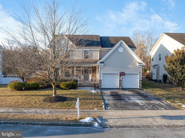 front facade with cooling unit, a garage, a front yard, and covered porch