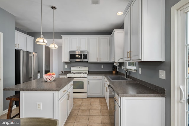 kitchen with a kitchen bar, white cabinetry, a kitchen island, pendant lighting, and stainless steel appliances