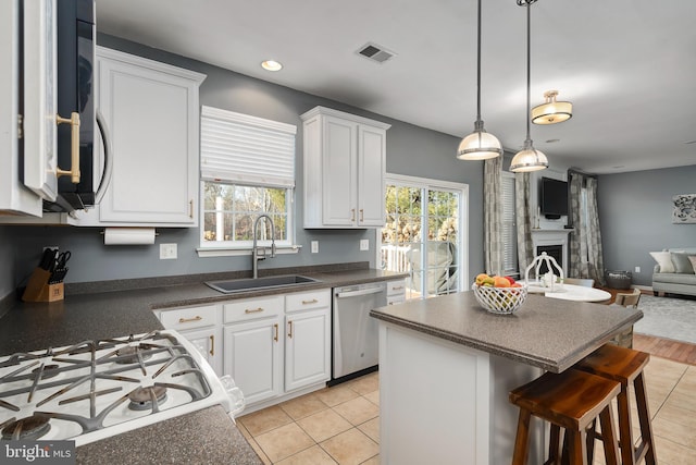 kitchen featuring a center island, sink, stainless steel dishwasher, and white cabinets