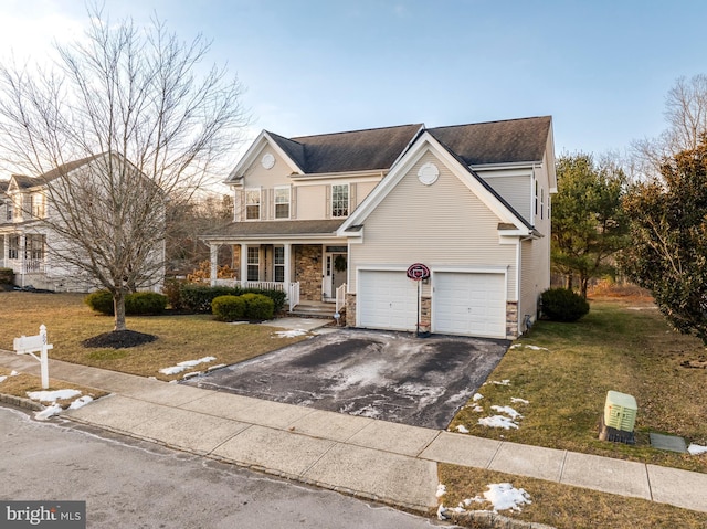 view of property with a garage, a front lawn, and covered porch