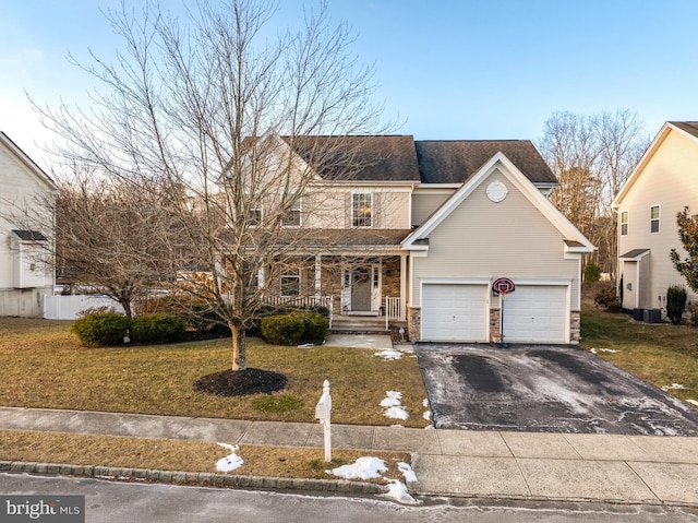 front of property with a garage, central AC unit, covered porch, and a front yard