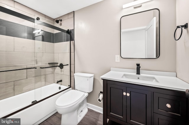 full bathroom with wood-type flooring, toilet, combined bath / shower with glass door, and vanity