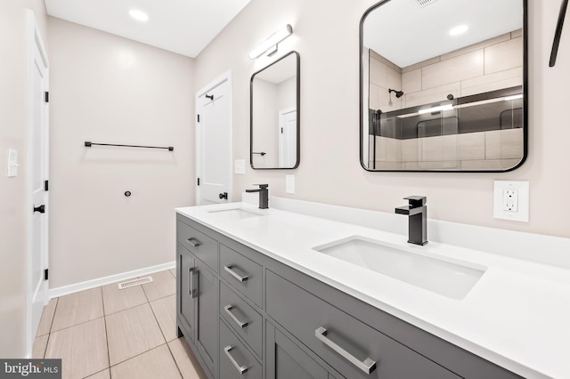 bathroom with tiled shower and vanity