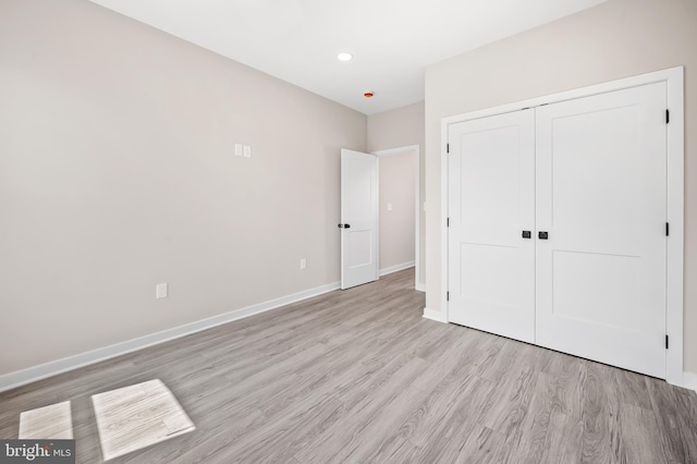 unfurnished bedroom with light hardwood / wood-style floors and a closet