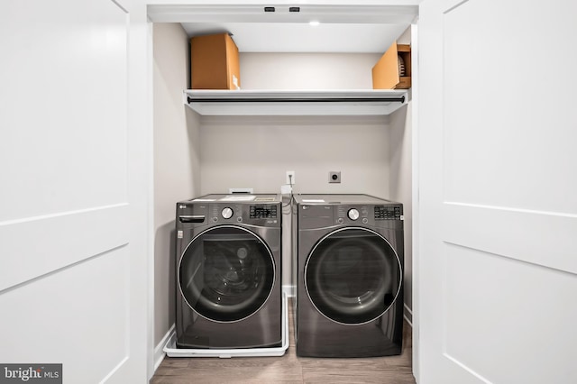 laundry area featuring hardwood / wood-style floors and washing machine and clothes dryer