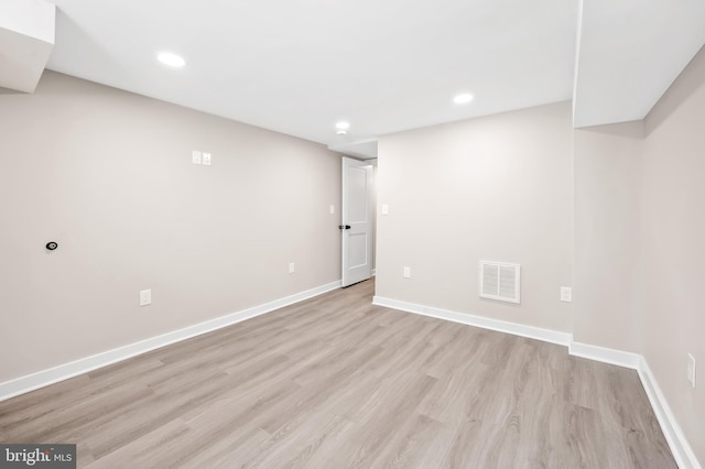 basement with light hardwood / wood-style flooring