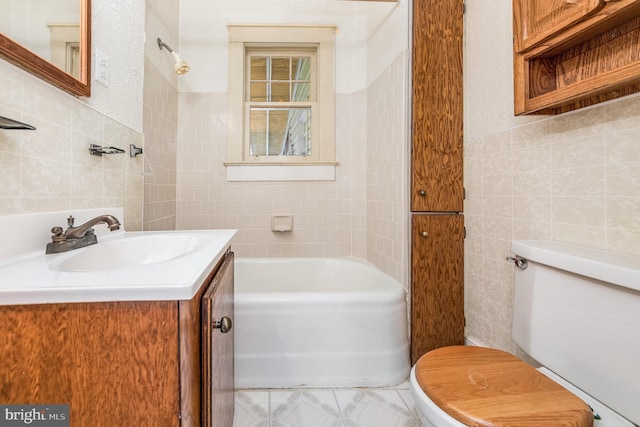 bathroom with vanity, toilet, and tile walls