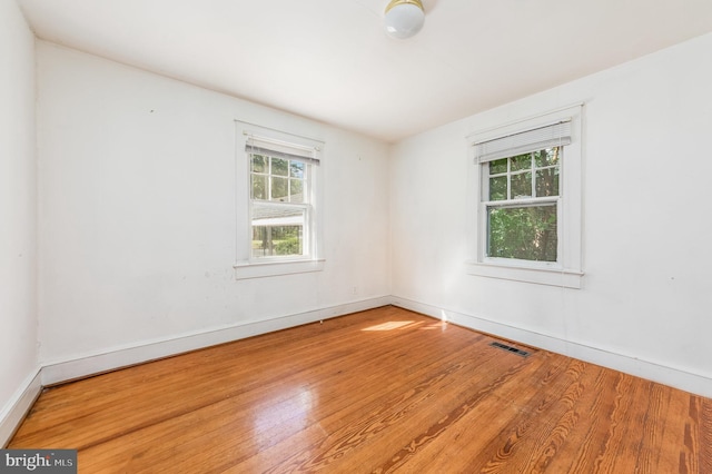 unfurnished room with hardwood / wood-style flooring