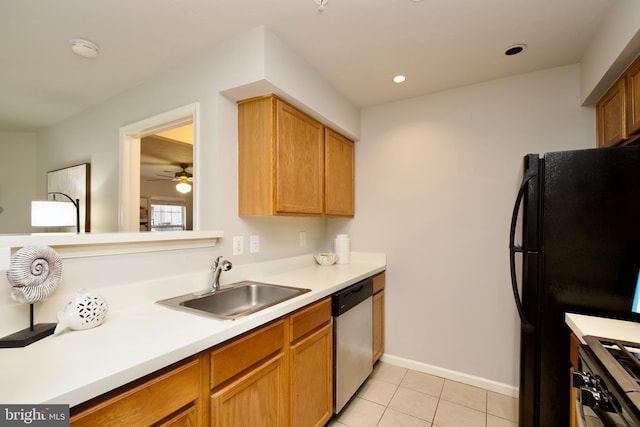 kitchen with sink, gas range, light tile patterned floors, black refrigerator, and dishwasher