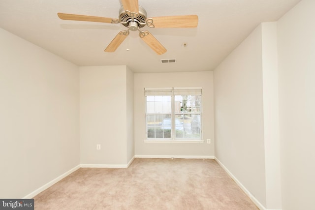 empty room featuring ceiling fan and light colored carpet