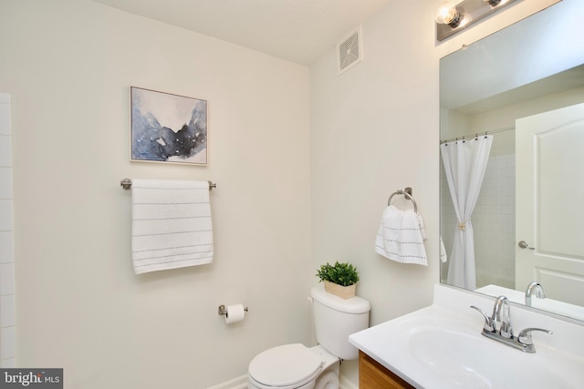 bathroom featuring vanity, a shower with shower curtain, and toilet